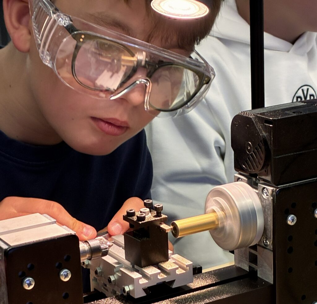 Ein Junior Maker Pioneer arbeitet an Mini-Drehmaschinen.